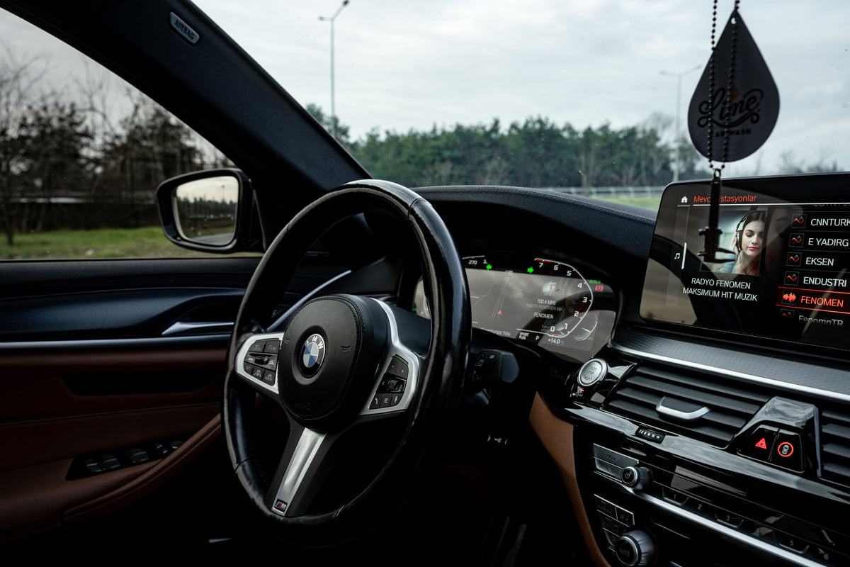 Luxury car interior featuring a sleek steering wheel and advanced dashboard display.